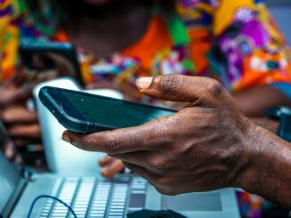 Nigerian man using a smartphone for mobile airtime transfer