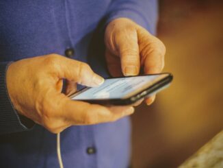 Hands holding a smartphone for mobile data access. Photo by Joshua Hoehne on Unsplash.