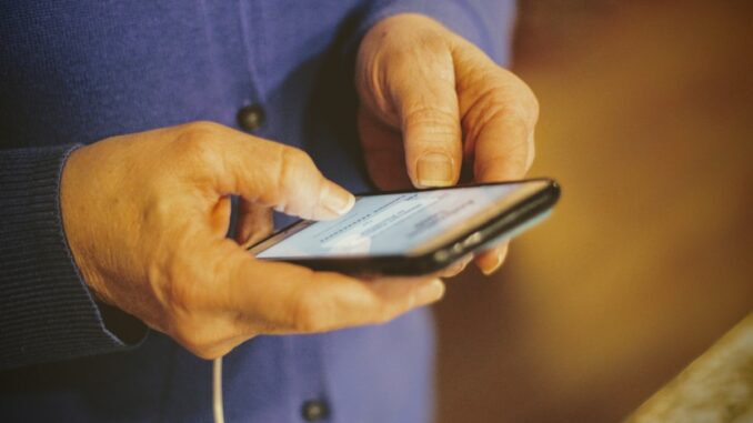 Hands holding a smartphone for mobile data access. Photo by Joshua Hoehne on Unsplash.