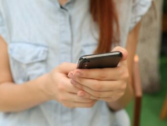Person using a smartphone for mobile communication. Photo by Yura Fresh on Unsplash.