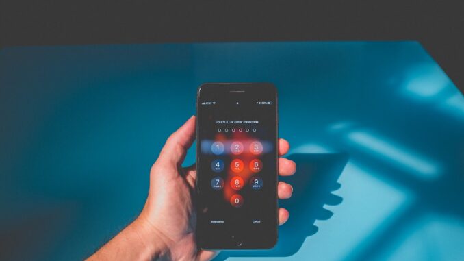 Person holding an iPhone while using a mobile service. Photo by Quilia on Unsplash.