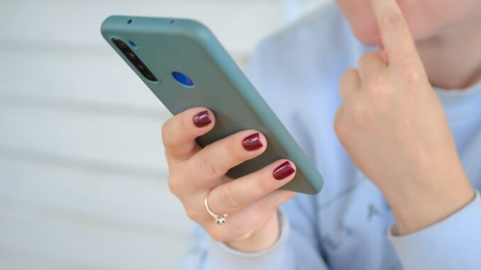 Person holding a smartphone for online connectivity. Photo by Konstantin Shmatov on Unsplash.